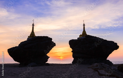 Beautiful silhouette of pagodas on rocks at sea during sunset twilight before getting dark with colourful sky in Myanmar photo