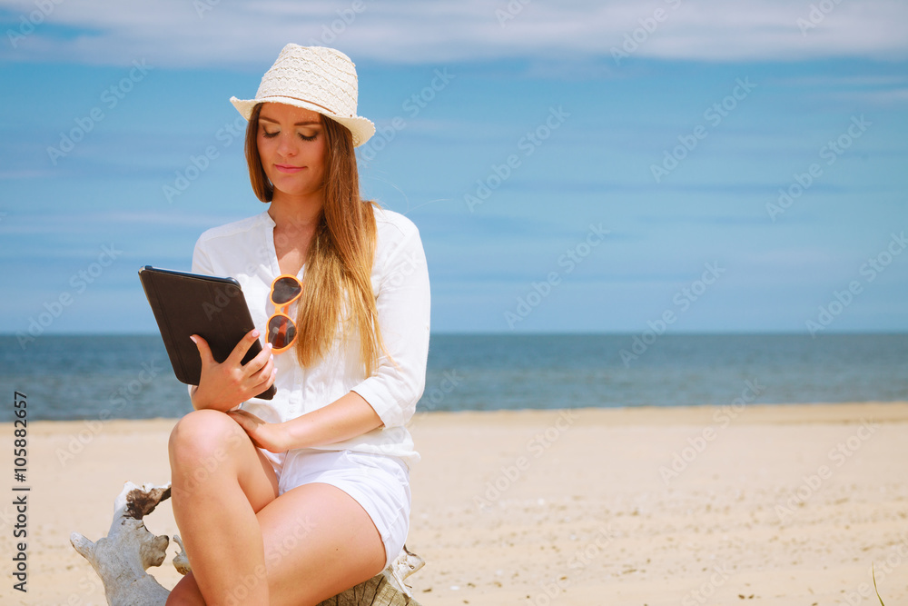 Girl with tablet on seaside.