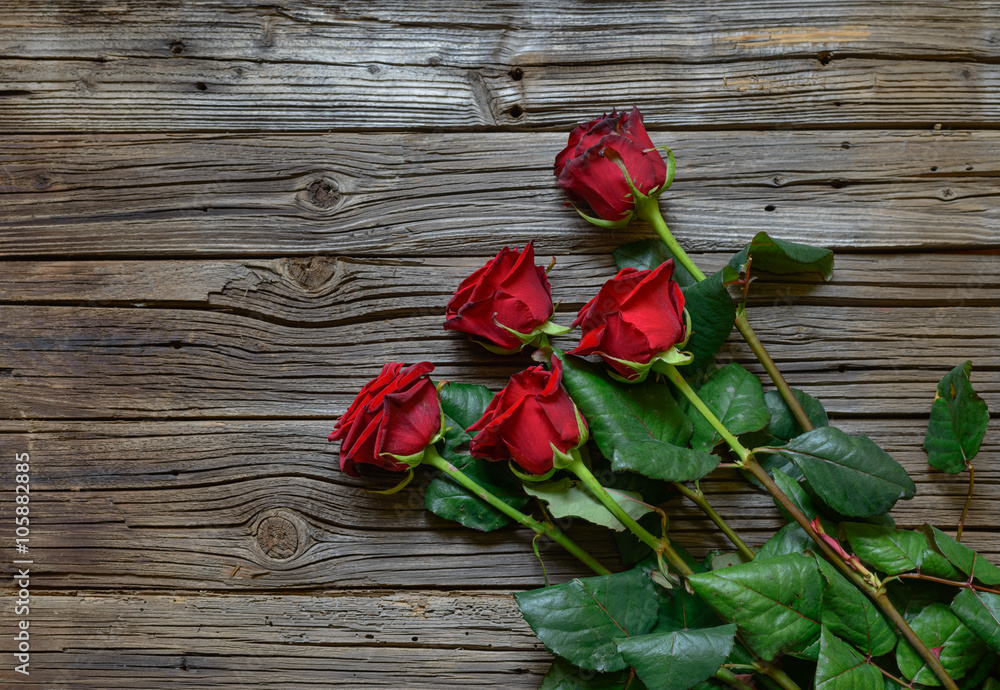 Romantic bouquet of red roses on a wooden surface