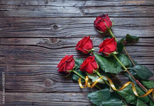 Romantic bouquet of red roses on a wooden surface