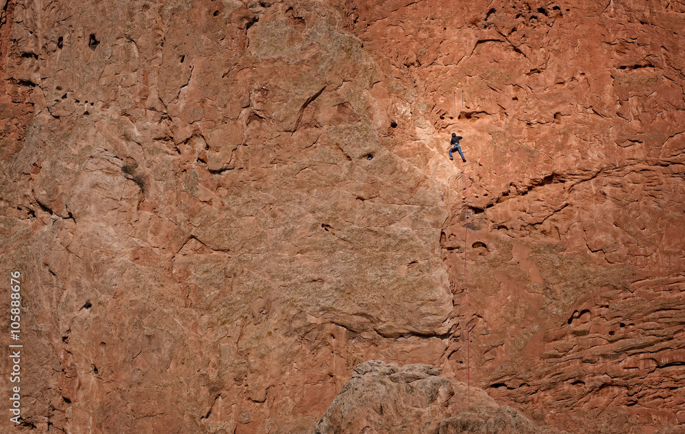 Rock Climber on a massive rock wall in Garden of the Gods, Colorado Springs, Colorado, USA.