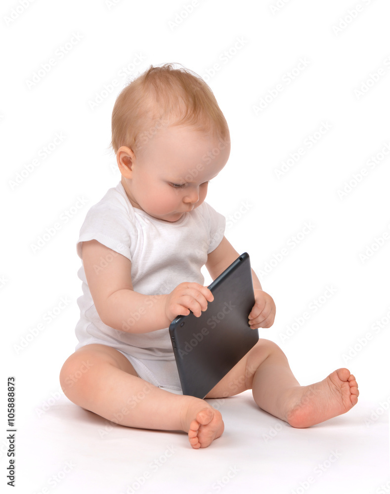 Infant child baby toddler sitting and typing digital tablet mobi Infant child baby toddler sitting and typing digital tablet mobi