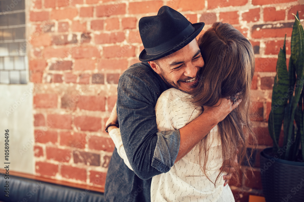 Young man hugging a woman in a coffee shop Young man hugging a woman in a coffee shop
