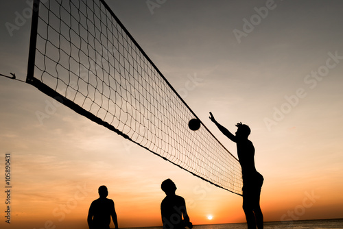 Beach volleyball silhouette at sunset , motion blurred