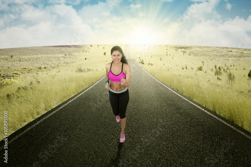 Runner doing exercise on the road © Creativa Images