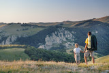 Man and young boy standing in a mountain meadow. 
