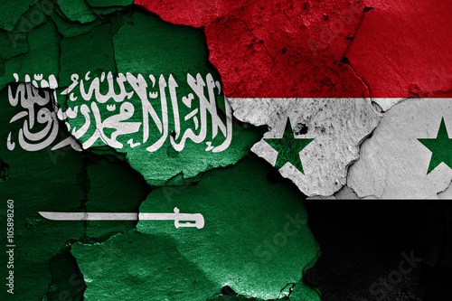 flags of Saudi Arabia and Syria painted on cracked wall