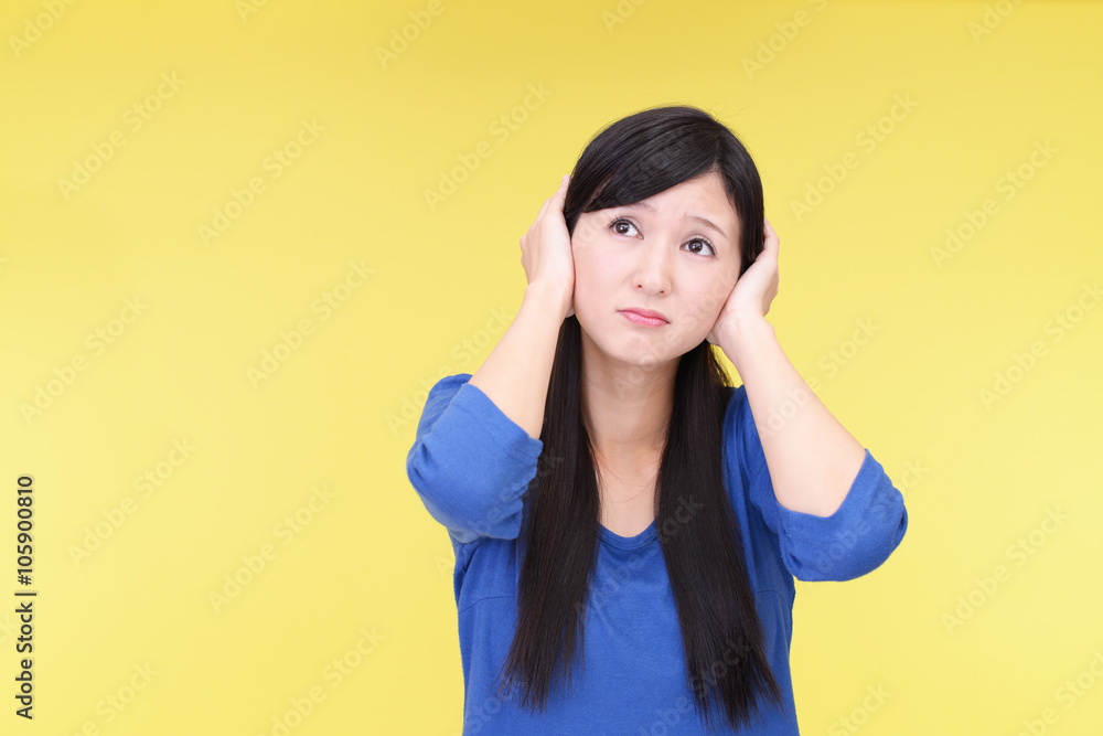 耳をおさえる女性