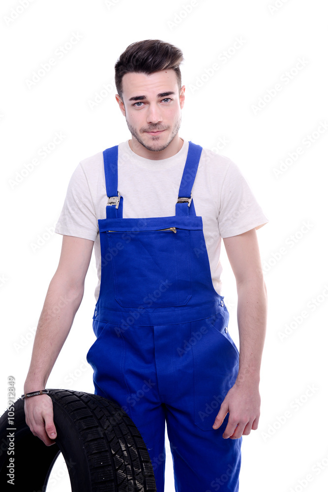handsome young mechanic holding a tire isolated on white background handsome young mechanic holding a tire isolated on white background