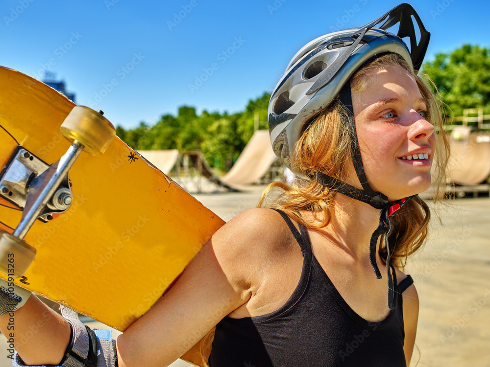 Teen girl skateboarding keeps her skateboard in park outdoor. Teen girl skateboarding keeps her skateboard in park outdoor.