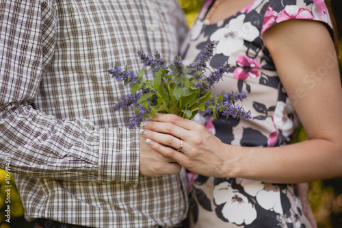 Pair is holding hands and bouquet
