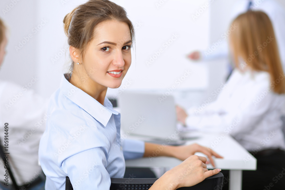 Beautiful business woman on the background of business people during meeting Beautiful business woman on the background of business people during meeting