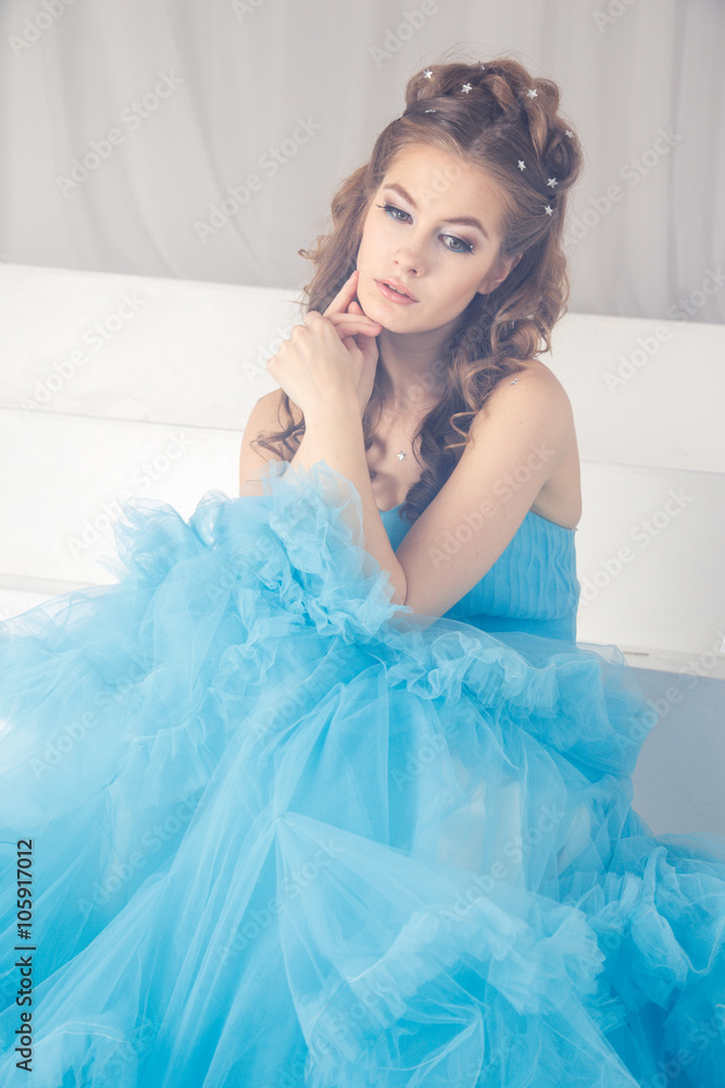 Beautiful young woman in gorgeous blue long dress like Cinderella with perfect make-up and hair style Beautiful young woman in gorgeous blue long dress like Cinderella with perfect make-up and hair style