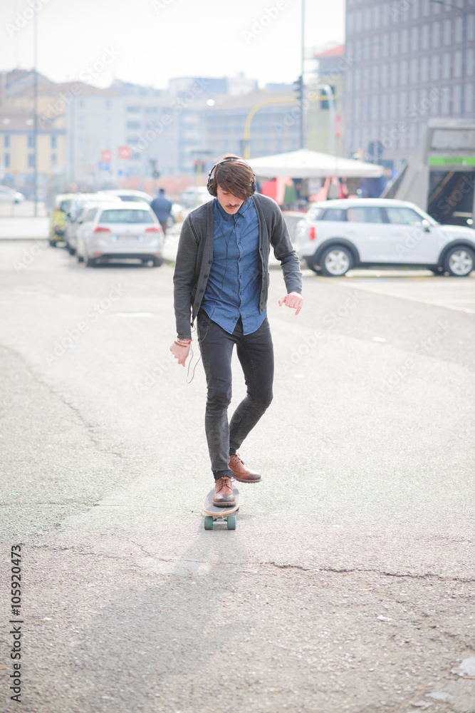 Young handsome caucasian man with mustache skating through the s Young handsome caucasian man with mustache skating through the s