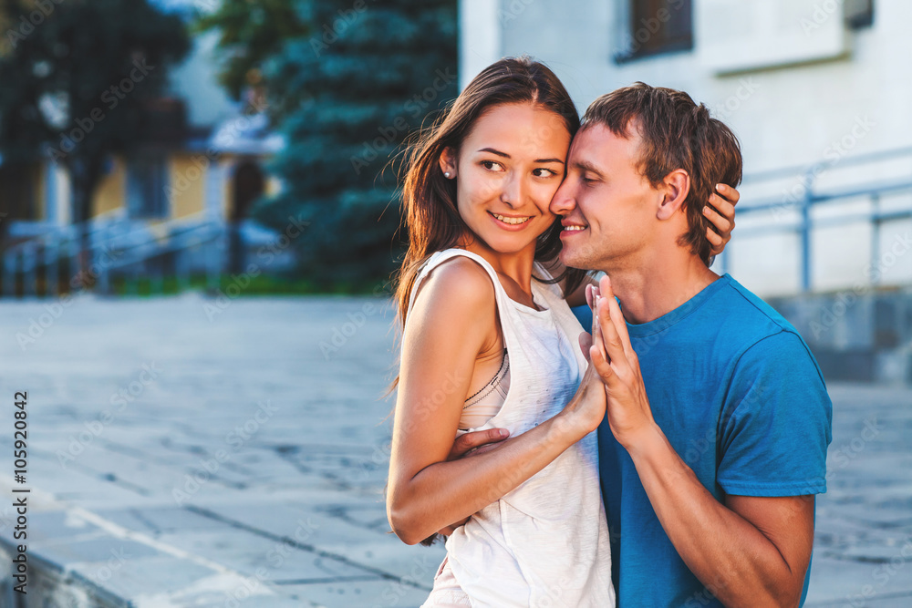 Obraz premium The guy embraces his girlfriend during a walk in the fresh air