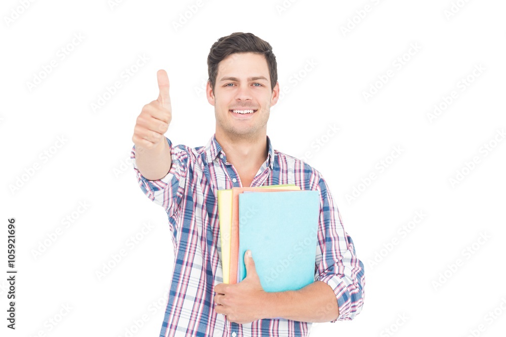 Portrait of male student holding books with thumb up Portrait of male student holding books with thumb up
