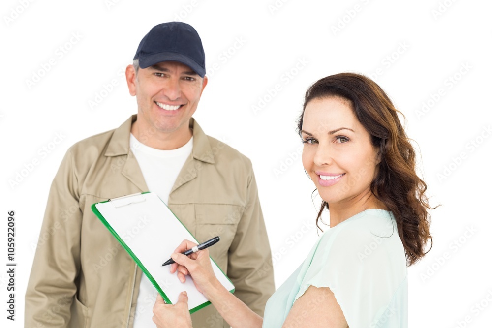 Female customer signing on paper with delivery man Female customer signing on paper with delivery man