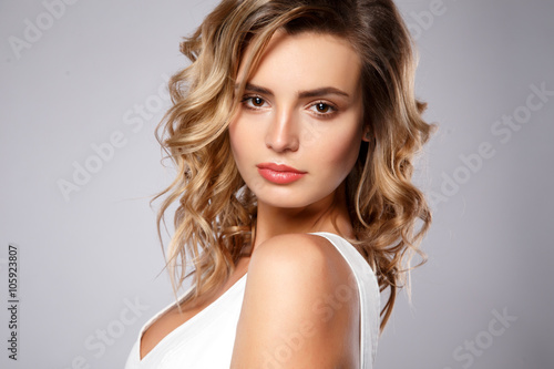 Close-up portrait of beautiful young woman with gorgeous hair and natural makeup. Fashion beauty photo