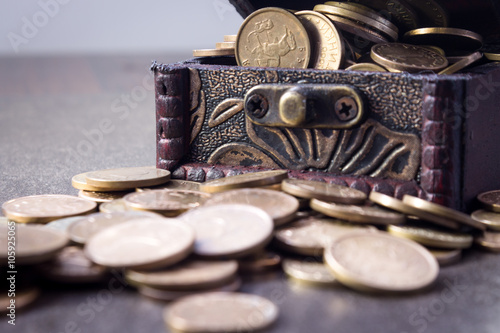 Coins in and out of wooden box 