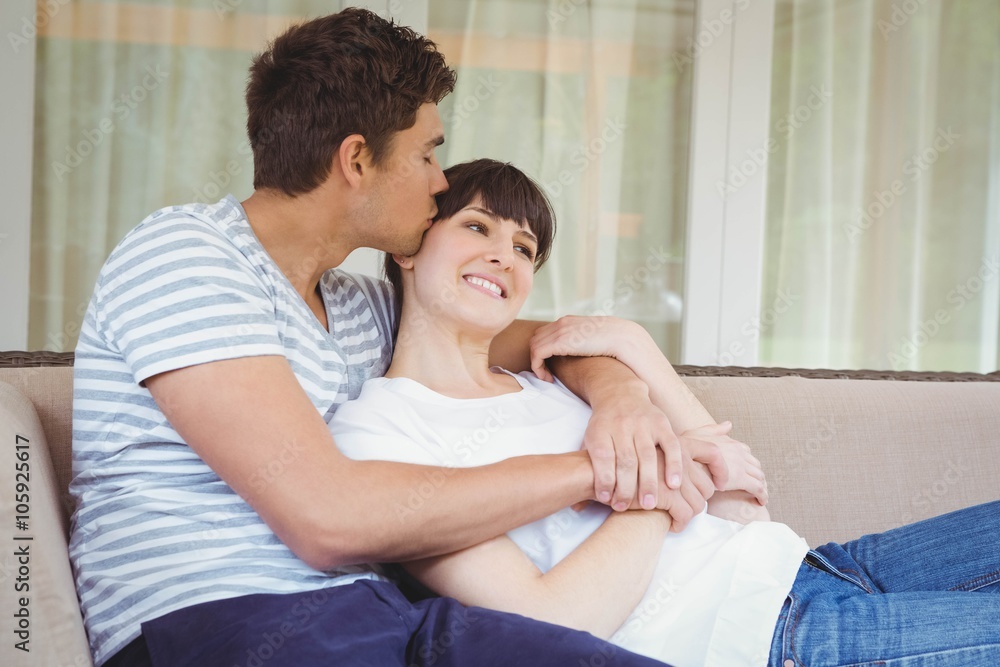Young couple cuddling on sofa Young couple cuddling on sofa