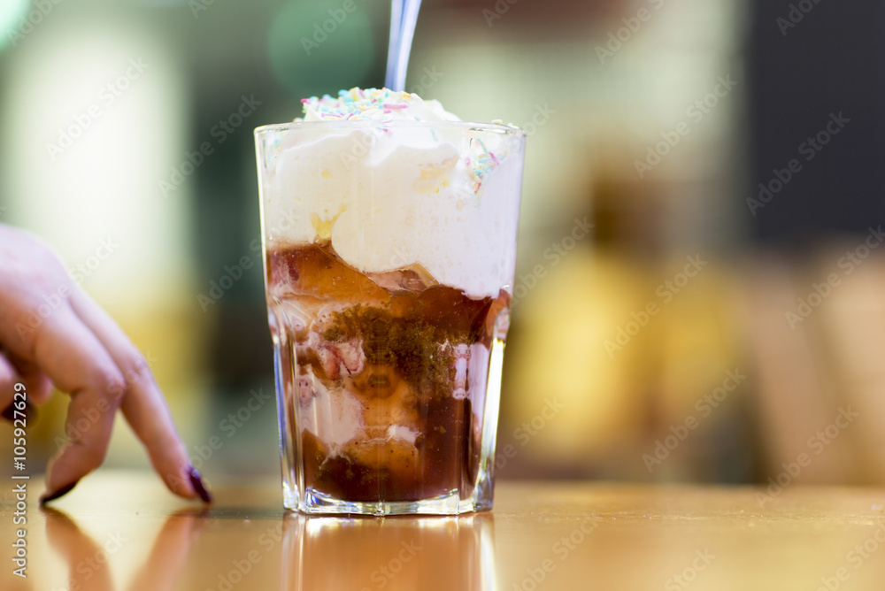 Dessert, chocolate ice cream in a glass. Fresh ice cream in a glass cup covered with whipped cream and sprinkled with icing. Dessert, chocolate ice cream in a glass. Fresh ice cream in a glass cup covered with whipped cream and sprinkled with icing.