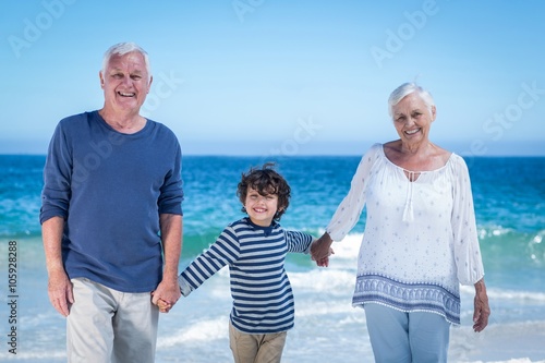 Cute boy holding his grandparents hands