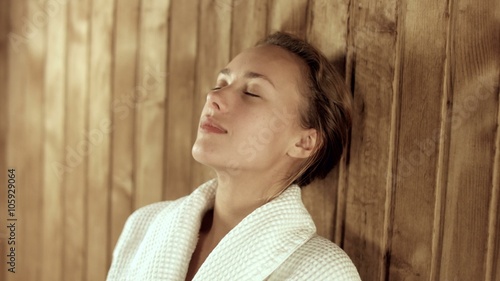 Relaxed woman relaxing in a wooden sauna