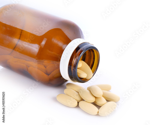Medicines, supplements and drugs in a glass bottle on a white ba