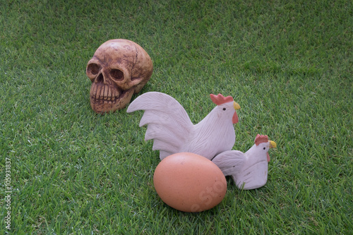 Принти на полотні Ceramic chickens and eggs on grass and human skull / Still life of ceramic hen a