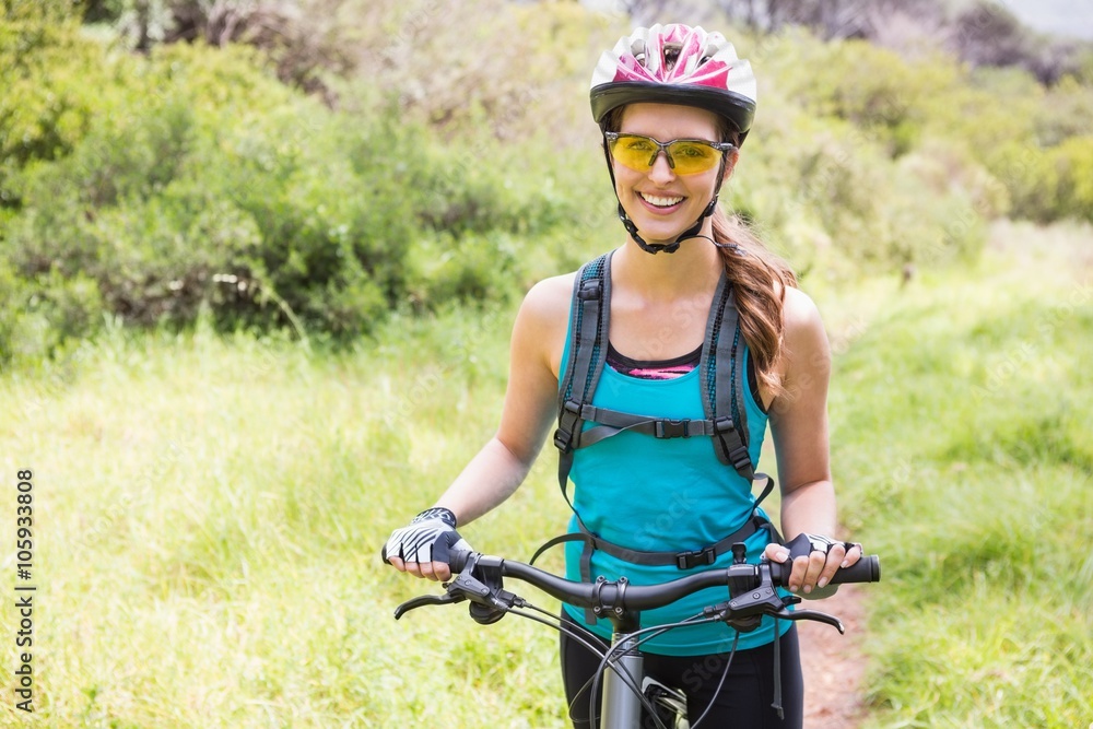 Obraz premium Smiling woman standing next to her bike