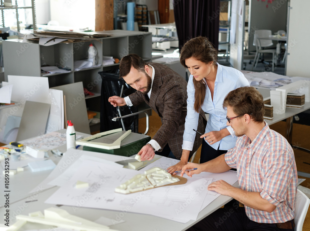 Confident team of engineers working together in a architect stud Confident team of engineers working together in a architect stud