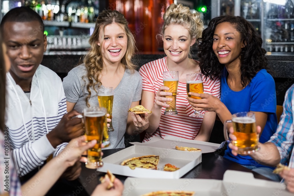 Happy friends having a drink and pizza