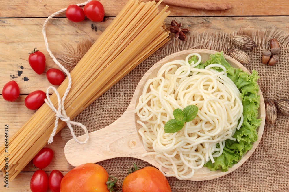 Spaghetti and raw spaghetti on wood background Spaghetti and raw spaghetti on wood background