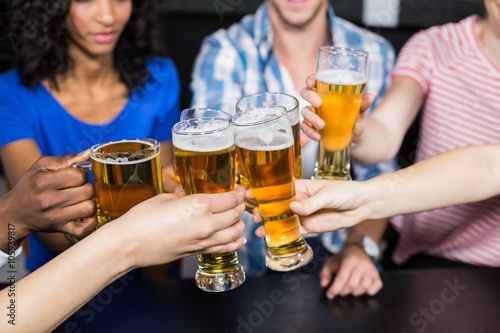 Happy friends drinking beer and toasting