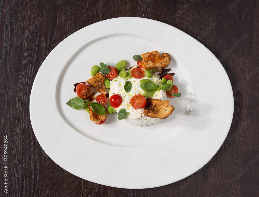 Delicious tomato and mozzarella cheese salad caprese, served on a white plate, with basil, croutons and balsamic vinegar. Delicious tomato and mozzarella cheese salad caprese, served on a white plate, with basil, croutons and balsamic vinegar.