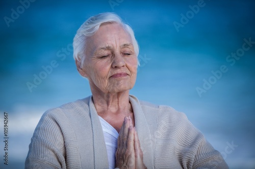 Senior woman relaxing with joined hands