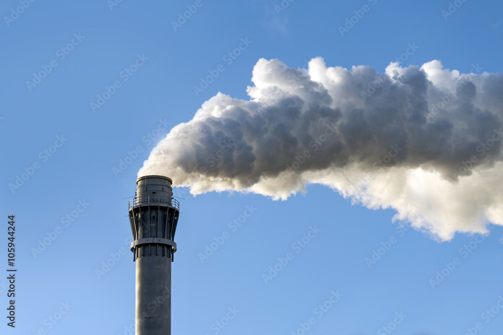 dark industrial smoke from a chimney against the clear blue sky, copy space dark industrial smoke from a chimney against the clear blue sky, copy space