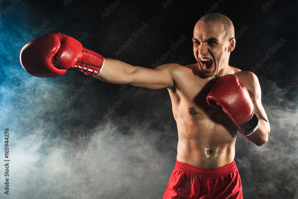 The young man kickboxing in blue smoke The young man kickboxing in blue smoke