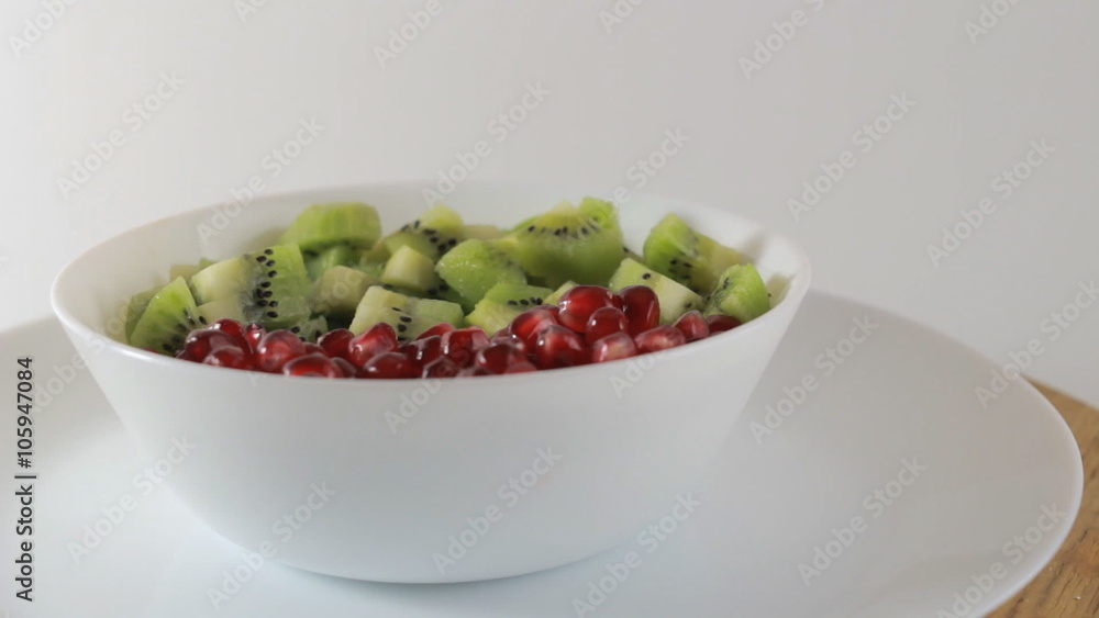 Kiwi and pomegranate on a white plate Kiwi and pomegranate on a white plate