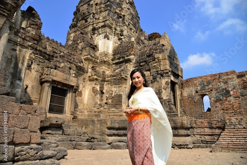 Asian model in traditional Thai dress in front of the religious buildings called as Phra Prang Sam Yod, the religious buildings constructed by the ancient Khmer art, Lopburi, Thailand. photo