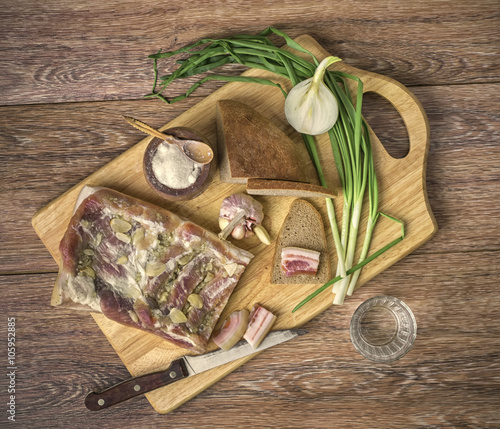 the salty bacon with onions and black bread on the wooden cuttin photo