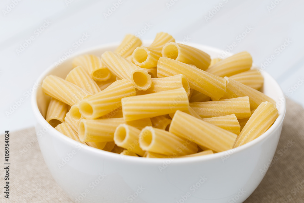 Raw tortiglioni pasta in a white bowl Raw tortiglioni pasta in a white bowl