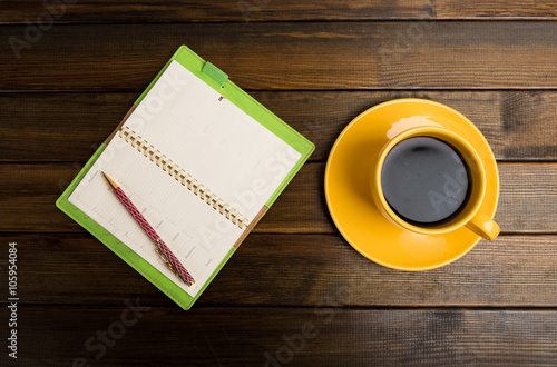 notebook, pen and cup of coffee in wood table