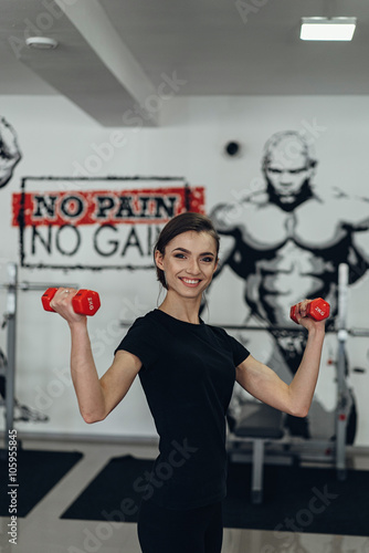 Beautiful girl in the gym with weights