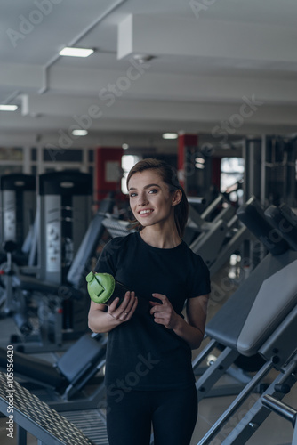 Beautiful girl holding a shaker in the gym