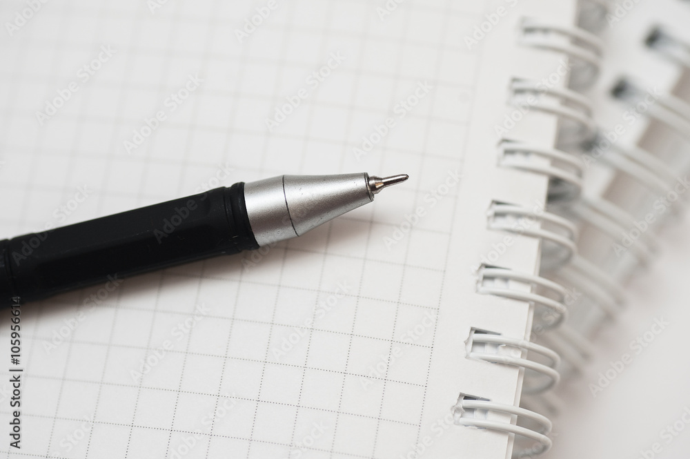 black pen lying on notebook close up black pen lying on notebook close up