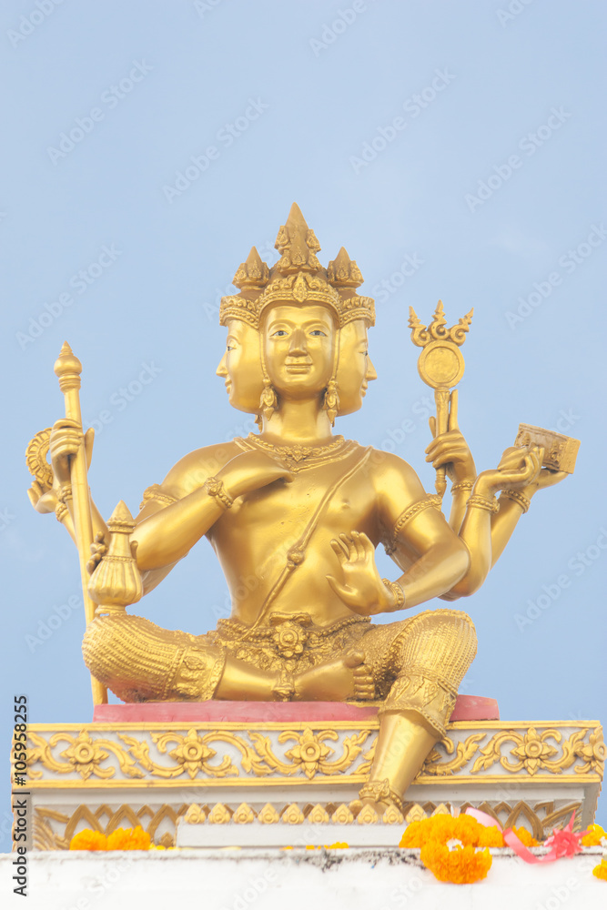 Fototapeta premium Hinduism Golden Brahma statue under blue sky