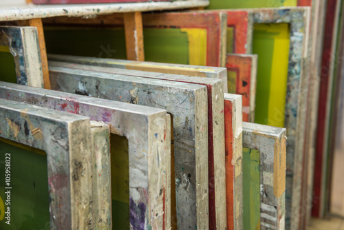 Silk screen printing screens stored in a wooden rack ready for printing. photo