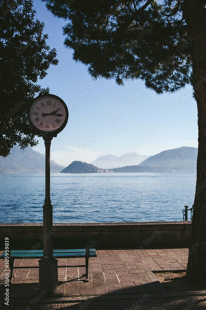 old clock in the shade on the shore of a mountain lake Como