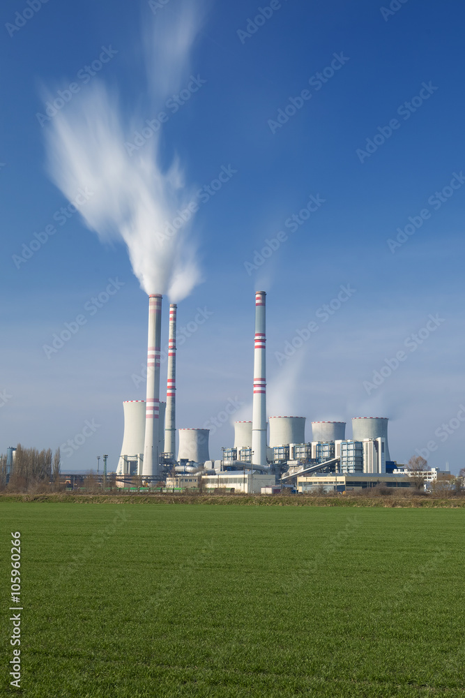 A coal-fired power station in the distance in agricultural landscape. Pocerady, Czech republic